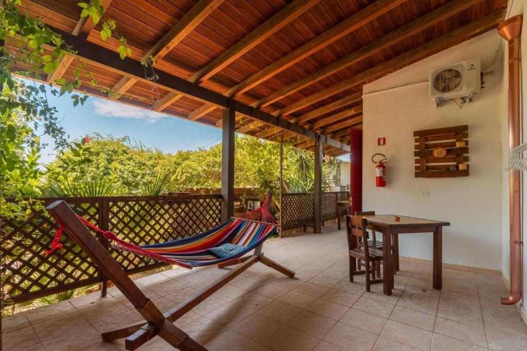 Veranda con amaca e tavolo in legno affacciata sul giardino