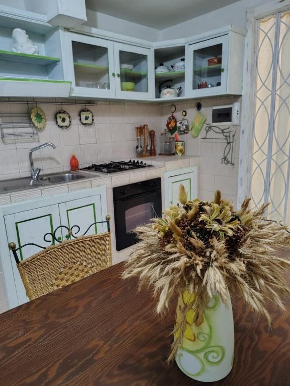 Cucina con mobili chiari e tavolo in legno massello
