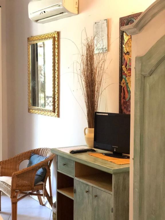 Angolo soggiorno con credenza in legno verde e specchio dorato